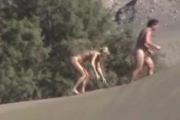 Couple naturiste se touche dans le désert